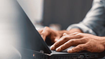 A person typing on a laptop to access the Winchester Savings Bank small business loan options.