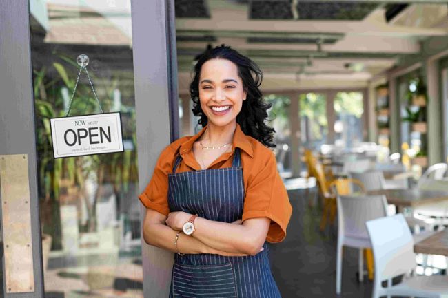 Barista smiling in front of her store