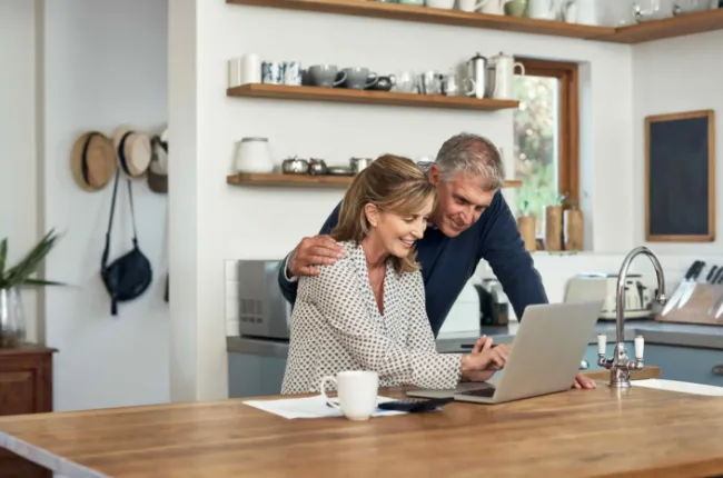 A mature couple looking at their laptop