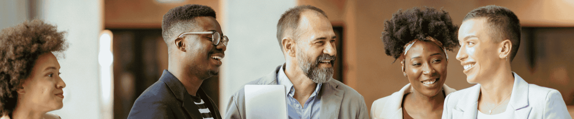 Diverse group of people smiling together, reflecting community, connection, and inclusivity.