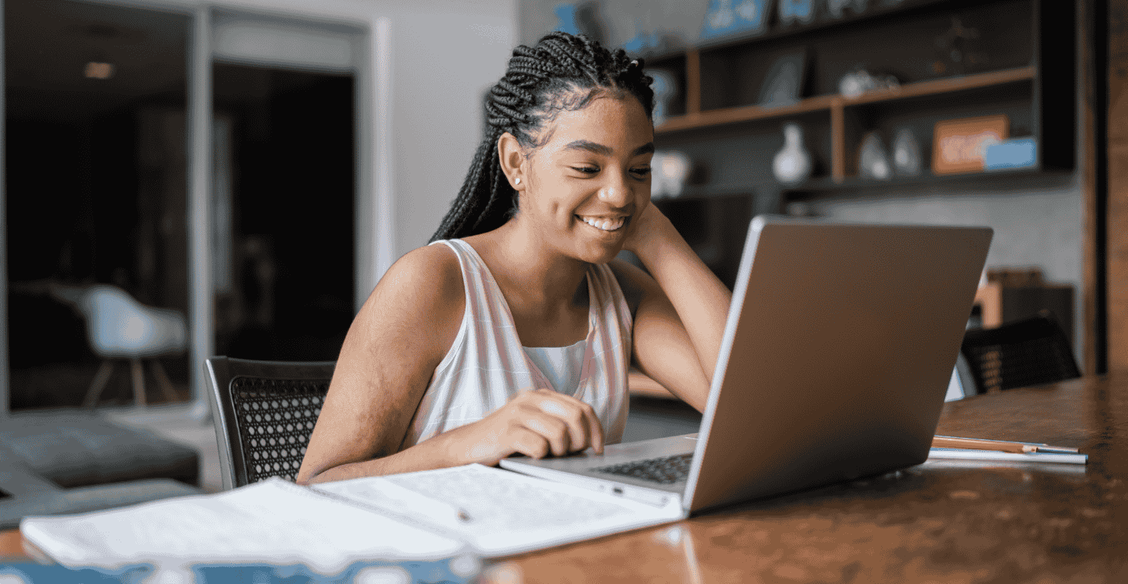 Teen girl using a laptop, highlighting digital learning, tech skills, and online access.