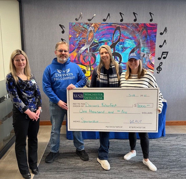 Winchester Savings Bank presents a donation check at Falconfest, supporting local schools and community events
